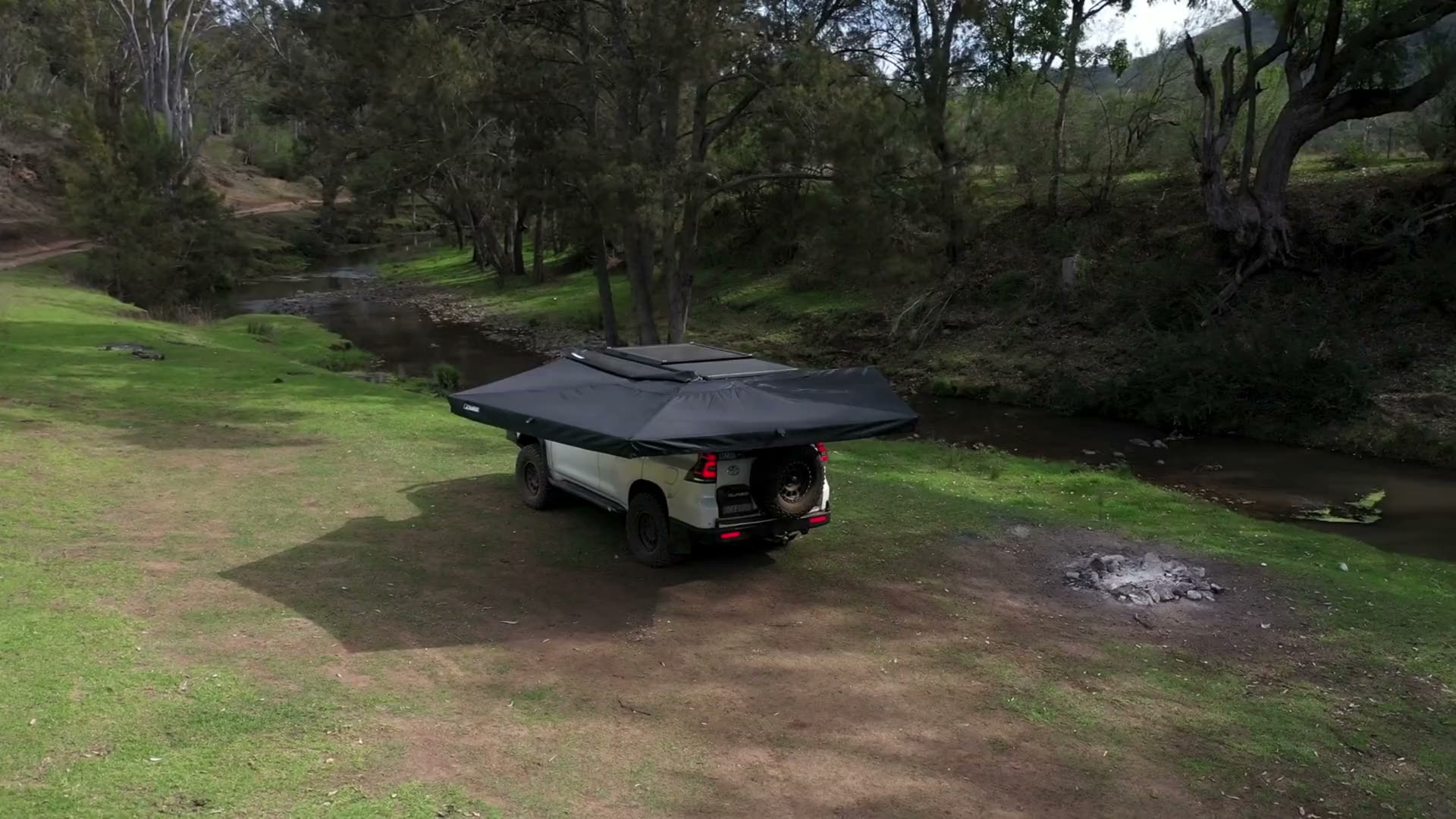 Rainger Duo 2.5M 270 degree awning deployed on a Prado beside a creek